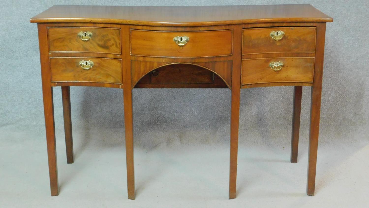 A small Regency mahogany serpentine fronted sideboard with an arrangement of five drawers and fitted