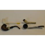 Two antique clay pipes along with two vintage chrome and wood pipes. One of the clay pipes is