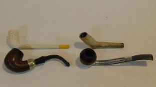 Two antique clay pipes along with two vintage chrome and wood pipes. One of the clay pipes is