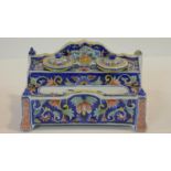 A Continental faience inkstand with twin inkwells and pen tray and allover polychrome foliate
