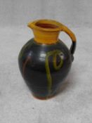 A large Clive Bowen (born 1943) Studio slipware pottery jug with abstract design on a dark