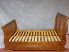 A contemporary Empire style large double sleigh form bedstead to take a super king size mattress.