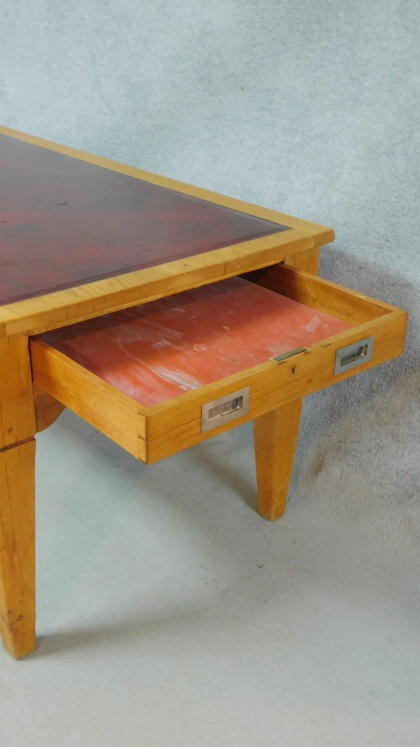 An early 20th Century light oak writing table with maroon tooled leather inset top above opposing - Image 4 of 9