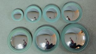 A set of seven convex wall mirrors graduating in size in moulded frames. 23x23cm (largest)