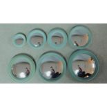 A set of seven convex wall mirrors graduating in size in moulded frames. 23x23cm (largest)