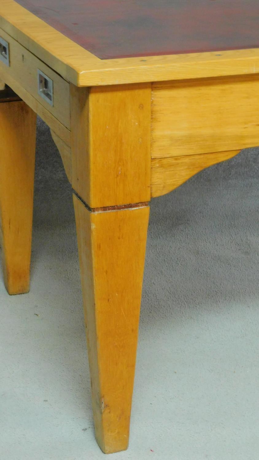 An early 20th Century light oak writing table with maroon tooled leather inset top above opposing - Image 6 of 9