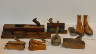 A collection of antique wooden shoemaker tools. Including a wooden and brass clamp, three pairs of