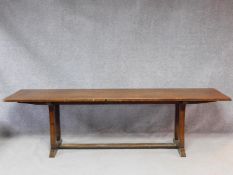 An oak refectory style dining table on stretchered chamfered square section supports on a platform