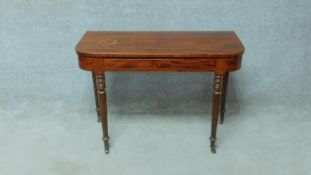 A late Georgian figured mahogany console table fitted with frieze drawer on turned tapering supports