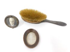 Two miniature photo frames and a silver backed brush. Miniature circular velvet backed easel photo