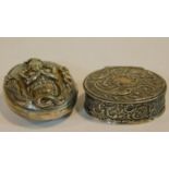 A white metal Indian locket box with Indian deity and snakes along with a repousse scrolling
