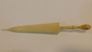 A carved bone stanhope in form of a parasol needle case. With sights from Bournemouth. W.13cm