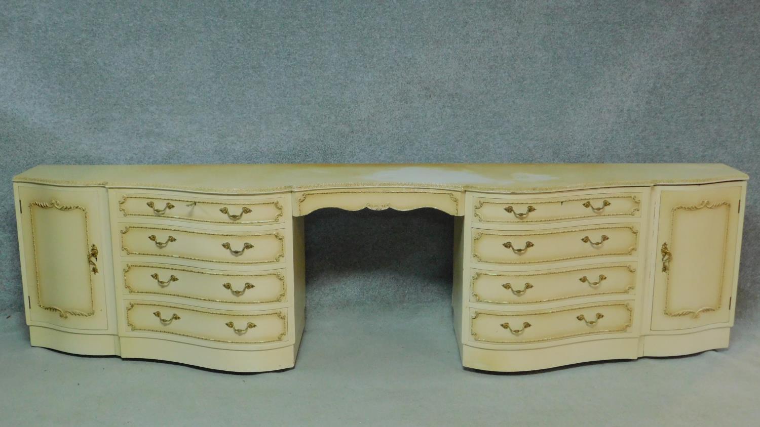 A mid century vintage cream and gilt sideboard or long dressing table fitted with kneehole section