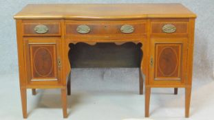 An early 20th century mahogany and satinwood inlaid desk with three frieze drawers over panel doors.