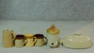 A miscellaneous collection of glazed stoneware pottery to include a foot warmer a jug and three