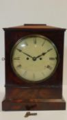 A Regency mahogany cased bracket clock with white painted dial and Roman numerals on plinth base.