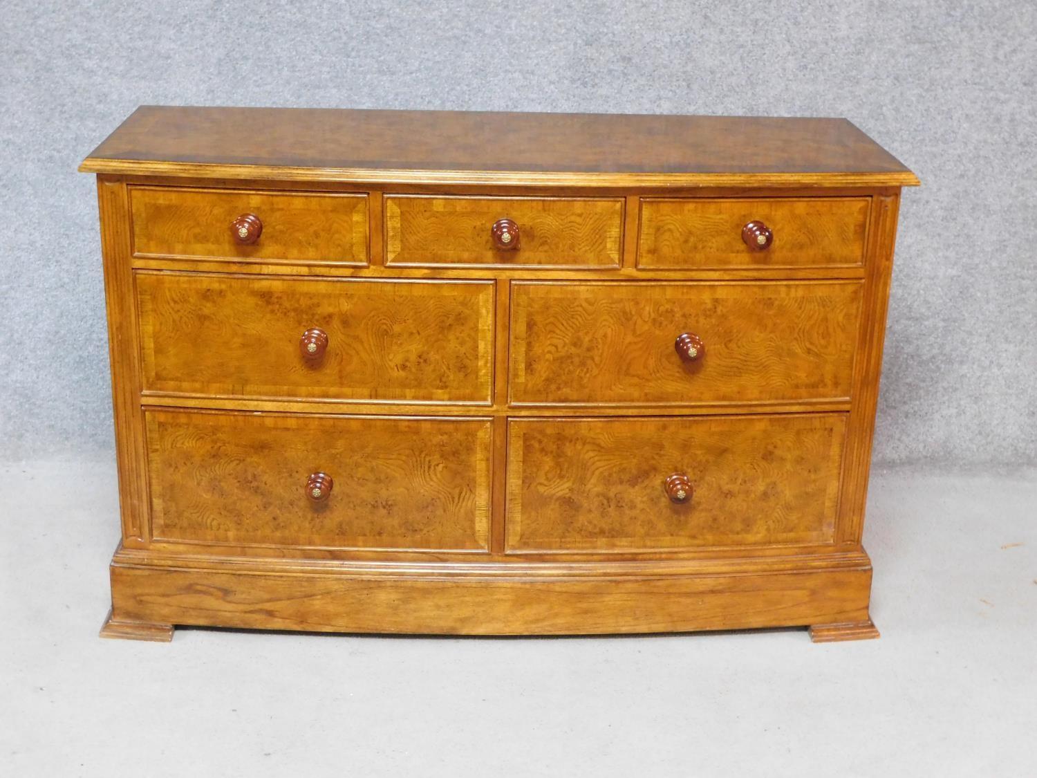 A Georgian style burr elm and crossbanded bowfronted chest of drawers on bracket feet, by Frank