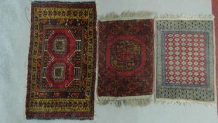 A Kazak rug with central lozenge medallions on a rouge field within floral multi borders and two