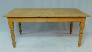 A Victorian pine planked top kitchen table fitted with frieze drawers to each end raised on turned