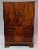 A mid century figured walnut cabinet with a pair of panel doors above drawers on bracket feet. H.110
