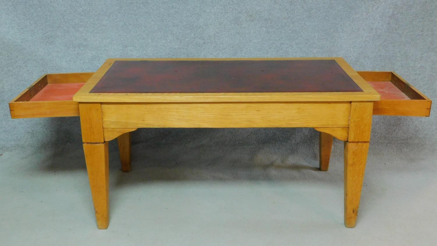 An early 20th Century light oak writing table with maroon tooled leather inset top above opposing - Image 3 of 9