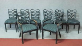 A set of eight ebonised dining chairs with scrolling lattice backs raised on square tapering