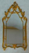 A gilt Rococo style pier mirror in shaped scrolling foliate frame. H.130 W.70cm