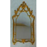 A gilt Rococo style pier mirror in shaped scrolling foliate frame. H.130 W.70cm