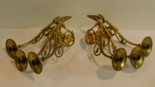 A pair of antique gilded brass wall mounted three branch candelabras with scrolling foliate