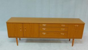 A mid century vintage teak Schreiber sideboard fitted with cupboards and drawers on shaped