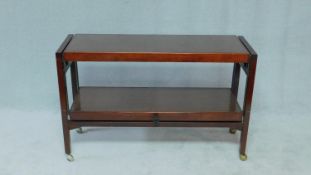 A vintage teak and metal framed serving trolley with metamorphic action. H.66 W.116 D.38cm