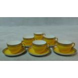 A set of six vintage bright yellow and black china tea cups and saucers with a relief stylised