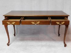 A 19th century style teak writing table with three frieze drawers on cabriole supports. H.76 W.140