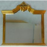 A gilt framed overmantel mirror with scrolling architectural pediment the plate flanked by pilasters