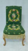 An early 20th century Continental nursing chair in tapestry style upholstery on carved cabriole