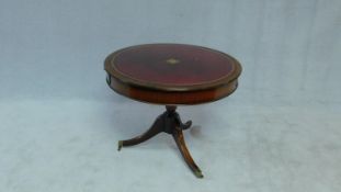 A Georgian style mahogany drum table with inset tooled leather top and opposing frieze drawers on