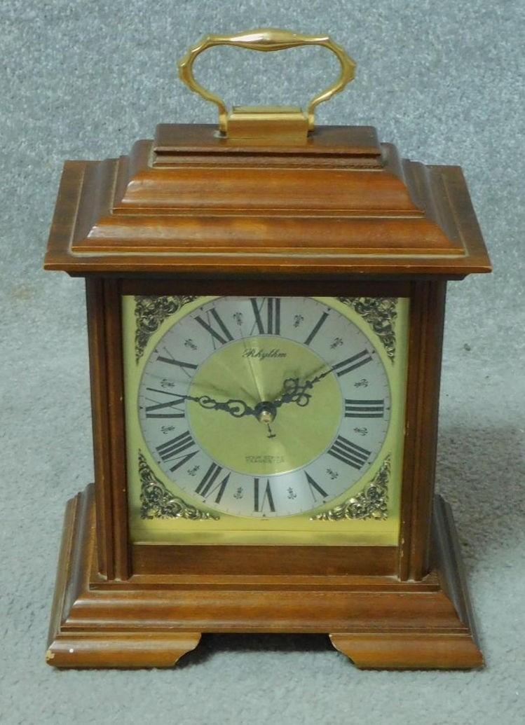 A Georgian style mahogany cased mantel clock with brass carrying handle on stepped bracket feet. H.