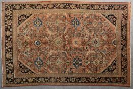 A Persian Mahal rug with repeating floral decoration and spandrels on a blush ground contained