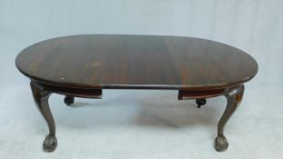 A Georgian style mahogany extending dining table on cabriole supports terminating in ball and claw