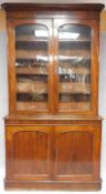 A 19th century mahogany library bookcase the glazed upper section above base with arched panel doors