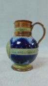 A Doulton Lambeth stoneware glazed Victoria diamond jubilee jug, with a scroll handle and two bands,