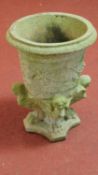 An urn shaped garden planter supported by winged caryatid on lion paw feet on shaped platform