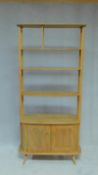 A vintage Ercol blonde elm "Giraffe" room divider, model 363, with four open tiers above base drawer