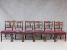 A set of six late Victorian carved walnut dining chairs on turned tapering supports. H.89cm