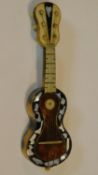 A miniature tortoiseshell guitar with mother of pearl inlay. W.13cm