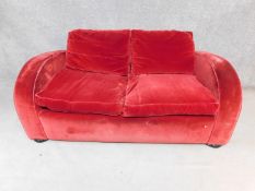 An Art Deco style two seater sofa in burgundy velour upholstery. H.77 W.176 D.96cm