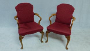 A pair of walnut framed Georgian style open armchairs in burgundy cut moquette upholstery on