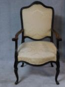 A 19th century Italian walnut open armchair with outswept arms on carved cabriole supports in