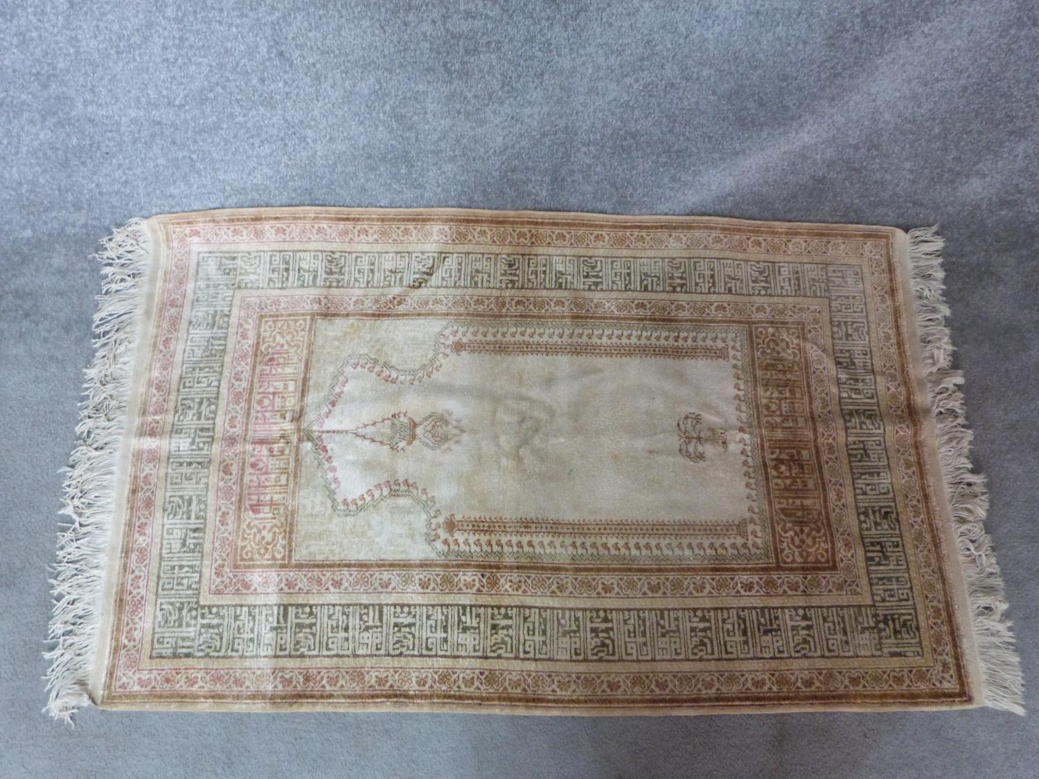 A woven Turkish prayer rug with Mehrab and lamp, mosque and calligraphy border design. 154x88