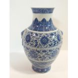 A large Chinese blue and white porcelain vase with stylised floral design and ring handles. Qianlong